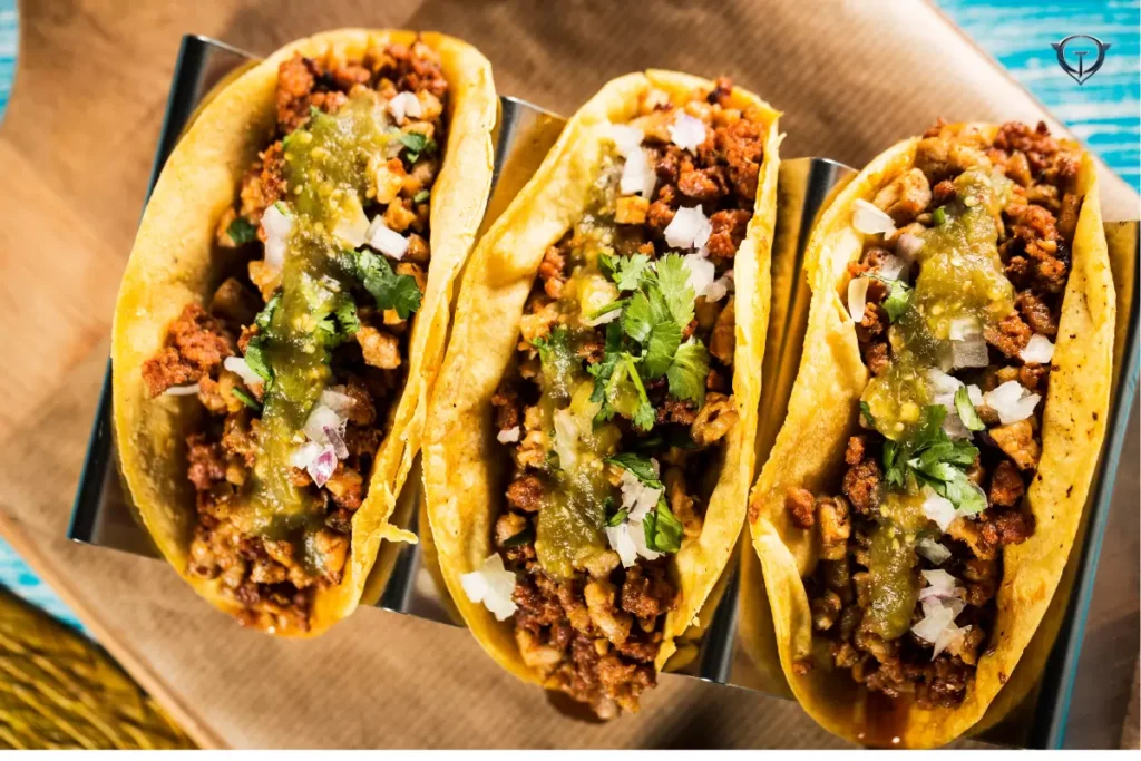 Close-up of tacos with colorful fillings like meat, vegetables, and salsa.