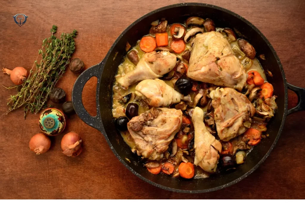 A plate of Coq au Vin with chicken, mushrooms, and red wine sauce.